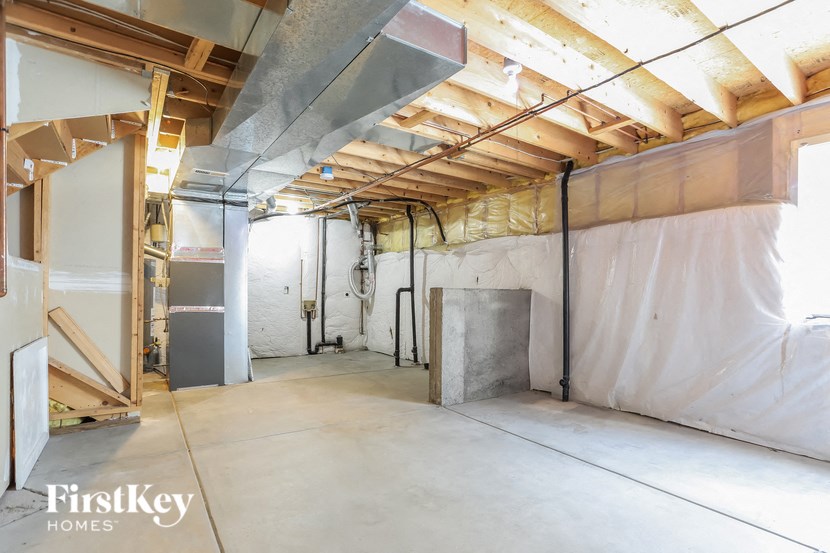 a large unfinished basement with unfinished walls and a concrete floor