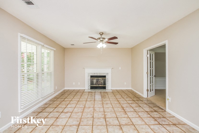 a living room with a fireplace and a ceiling fan