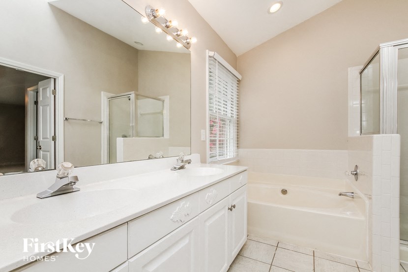 a bathroom with a white sink and a tub and a mirror