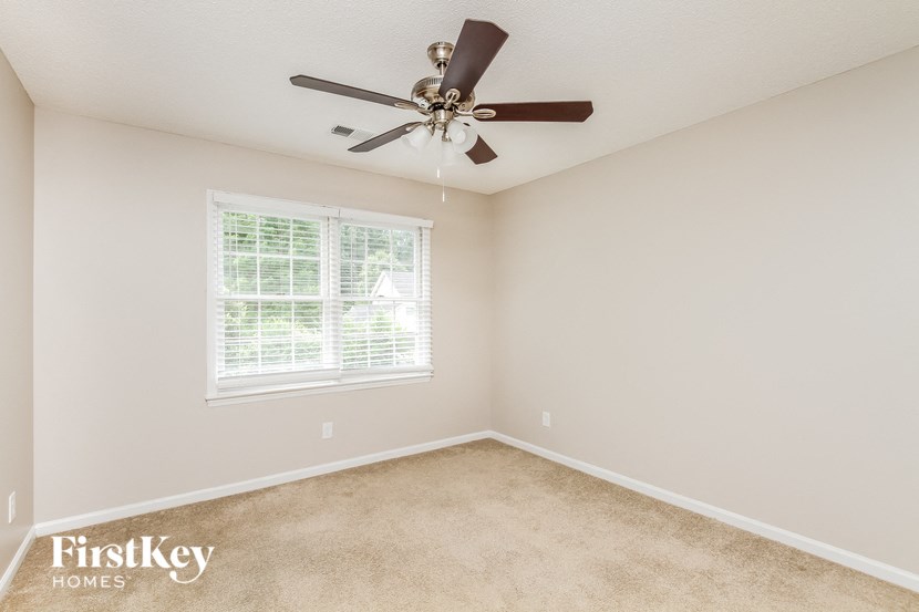 a bedroom with carpet and a ceiling fan
