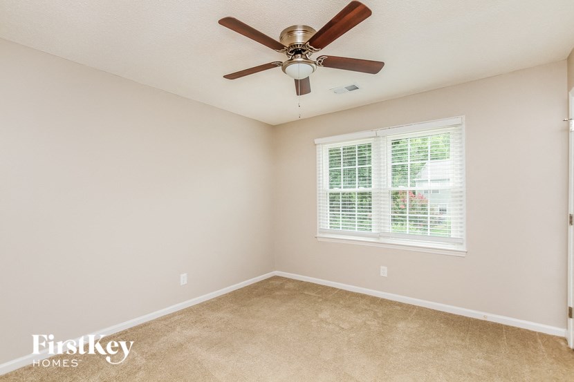 a bedroom with a ceiling fan and a window
