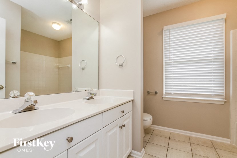 a bathroom with a large mirror and a sink and a toilet