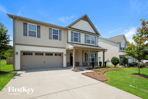 a beige house with a driveway and a garage door