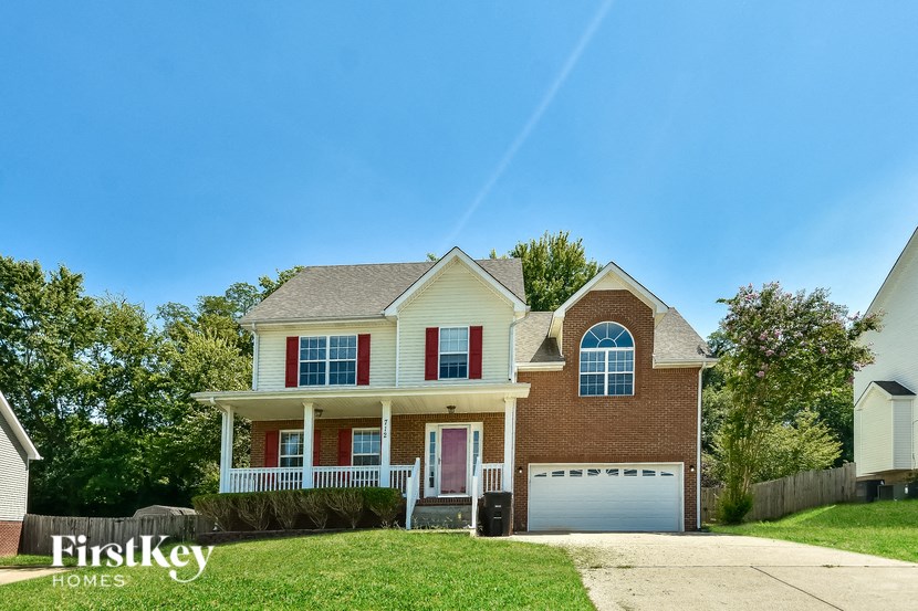 a brick house with red shutters and a white garage door