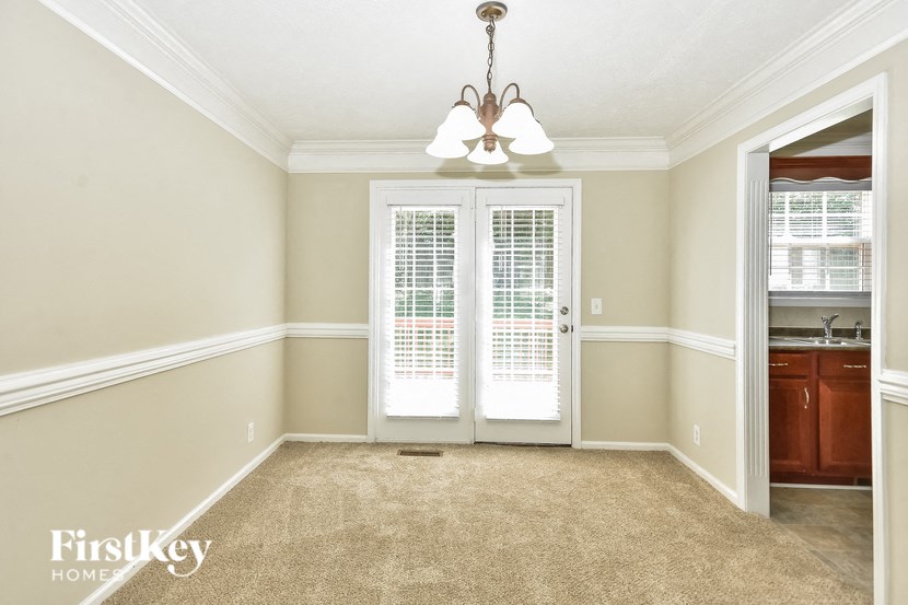 an empty dining room doors and a chandelier