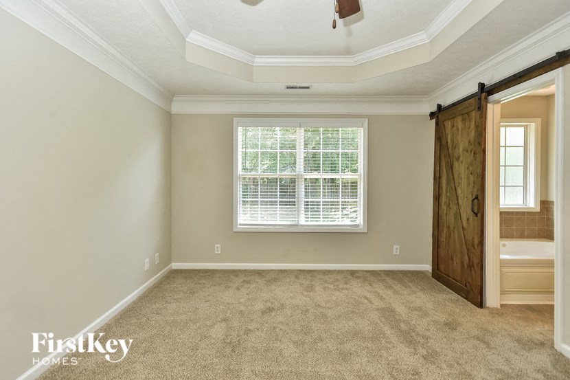 an empty room with a window and a wooden door