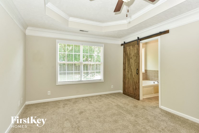 an empty bedroom with a window and a sliding door