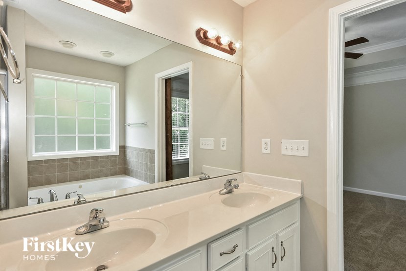 a bathroom with a sink and a mirror and a tub
