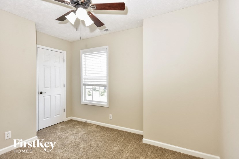 a bedroom with a ceiling fan and a white door