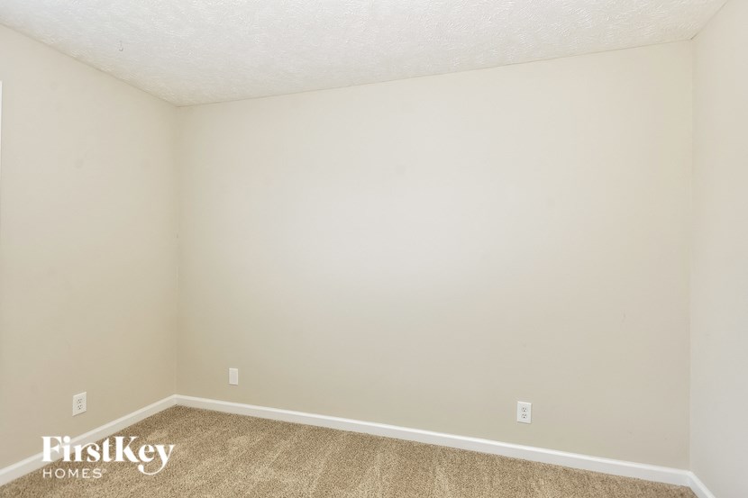 the living room of an empty house with white walls and carpet