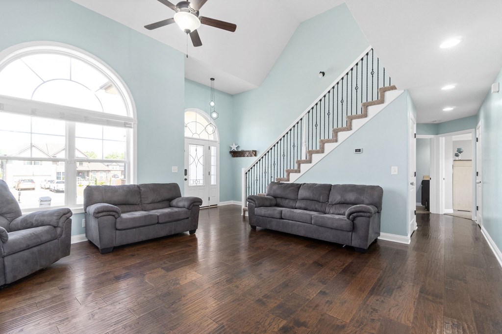 the living room of a house with two couches and a staircase