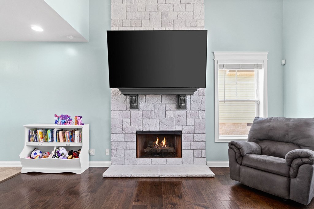 a living room with a fireplace and a tv above it