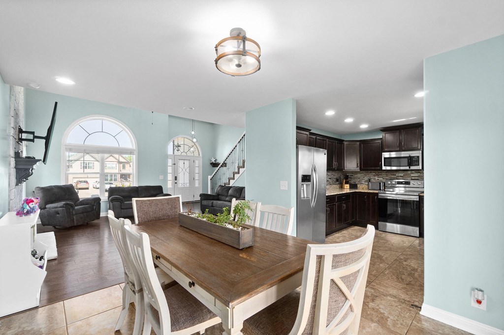 a dining room with a wooden table and chairs next to a kitchen
