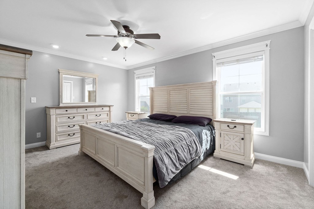 a bedroom with a bed and a ceiling fan