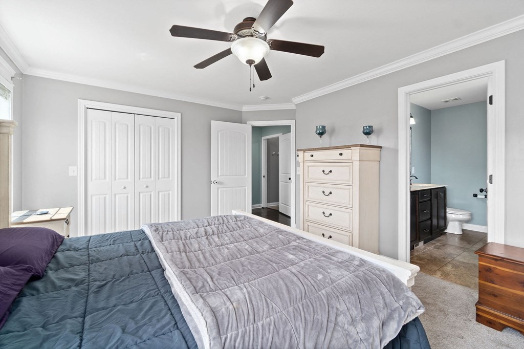 a bedroom with a large bed and a ceiling fan