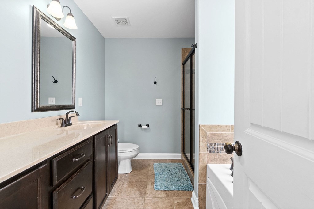 a bathroom with a toilet and a shower and a sink