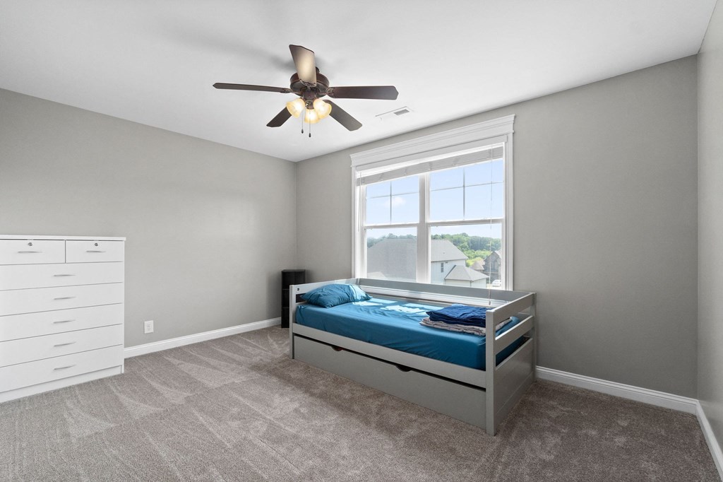 a bedroom with a bed and a ceiling fan