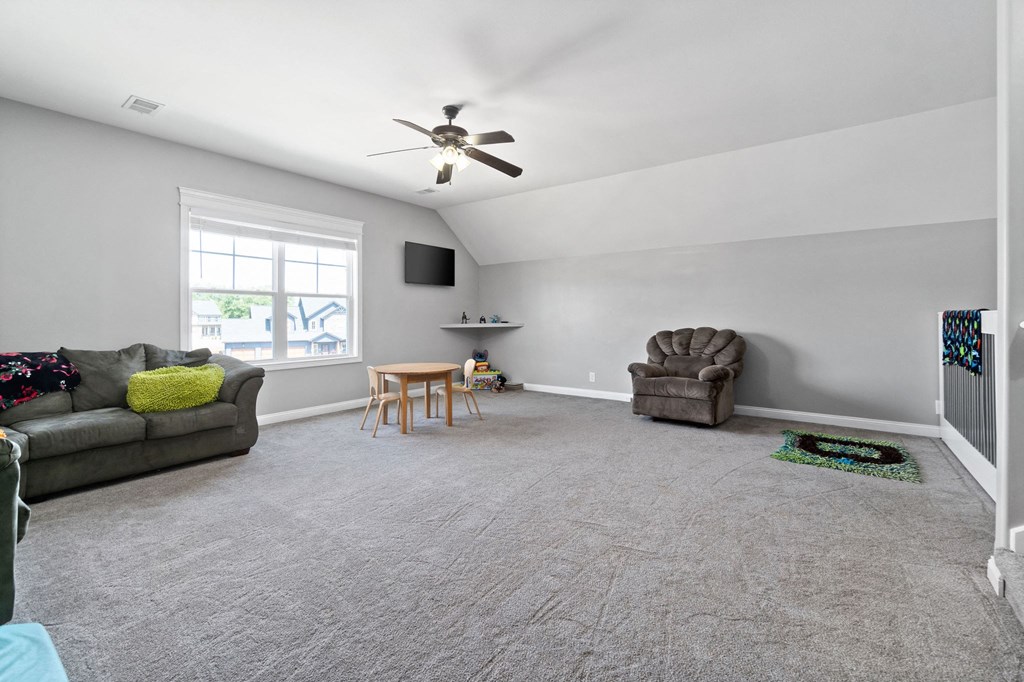 a living room with two couches and a chair and a ceiling fan