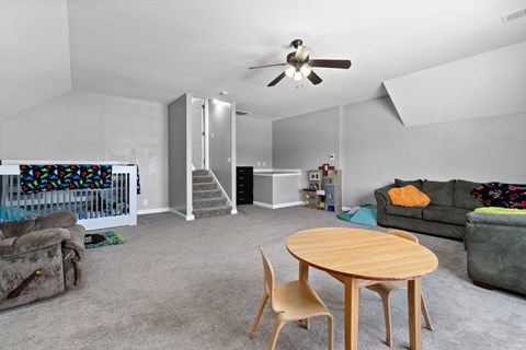 a living room with couches and a table and a ceiling fan