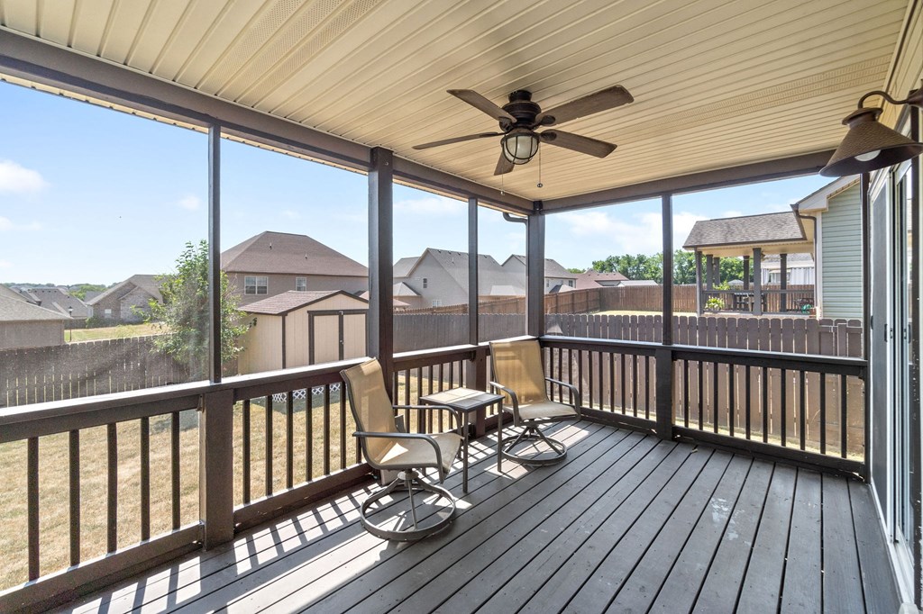 the deck has a rocking chair and a ceiling fan