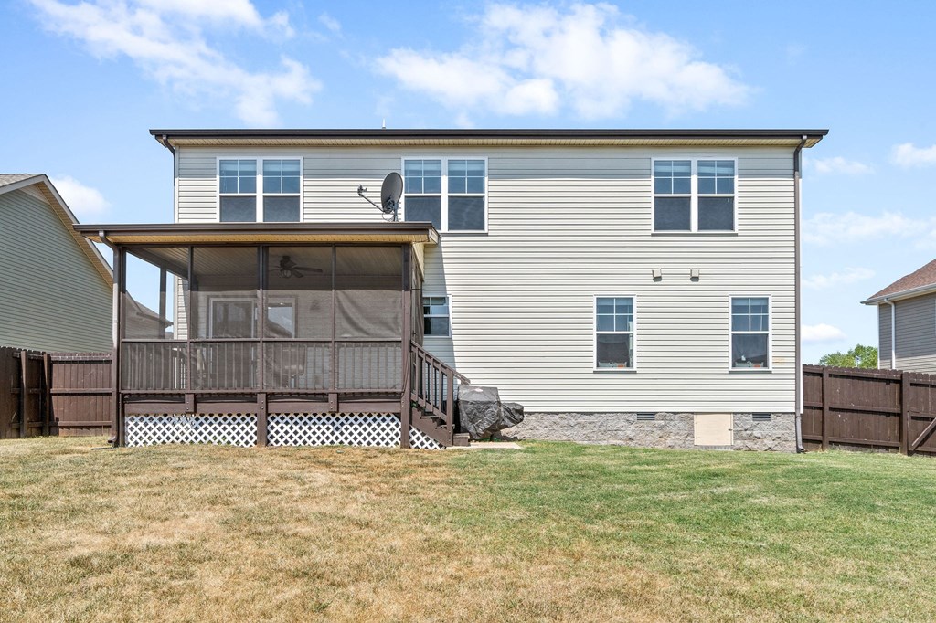 the back of a house with a deck and a yard