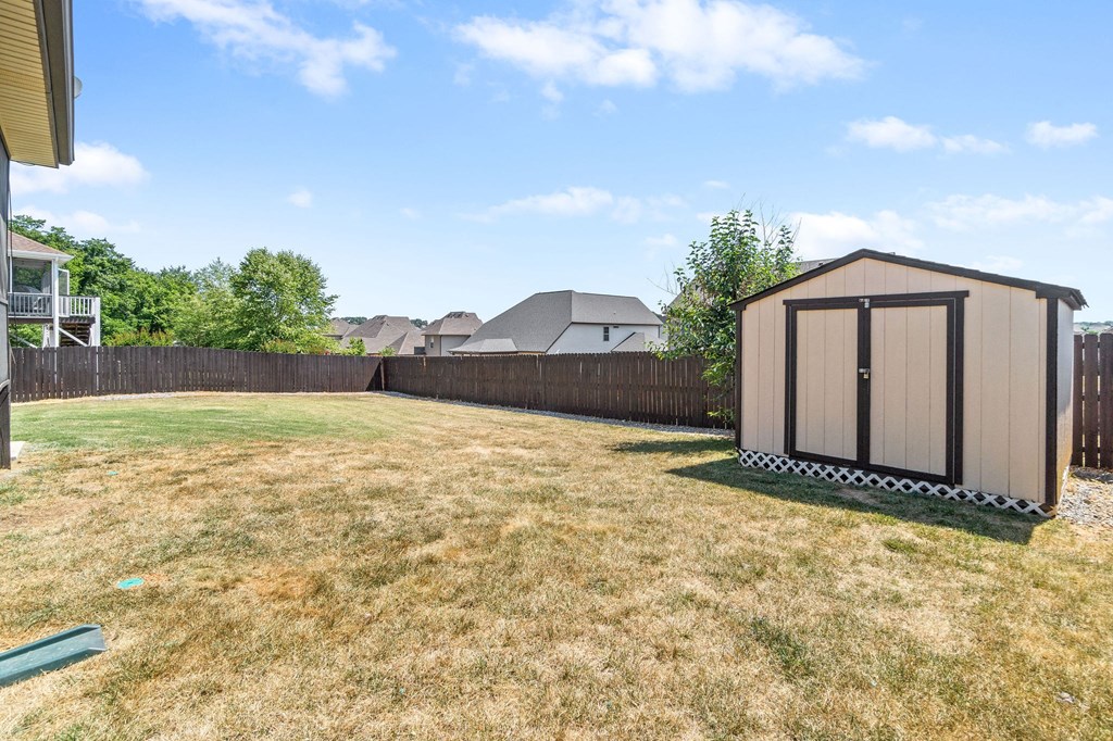 a backyard with a shed and a fence