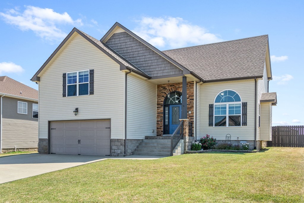 a beige house with a garage and a lawn