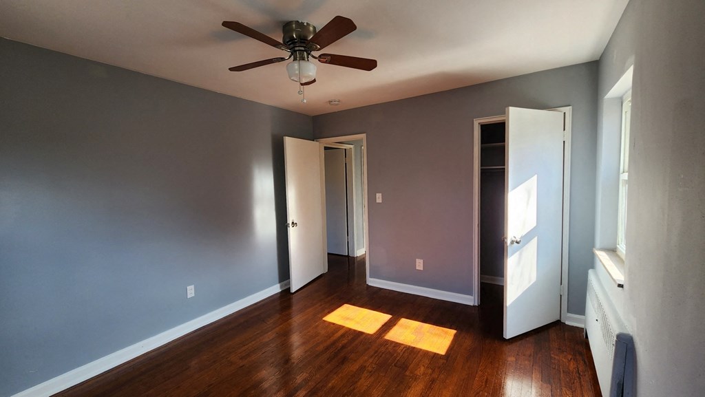 a living room with wood floors and a ceiling fan