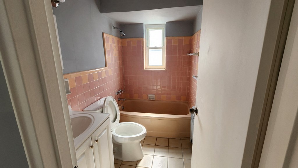 a bathroom with a toilet and a tub and a sink