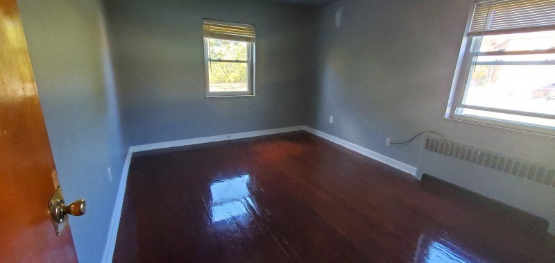 a empty room with a wooden floor and a window