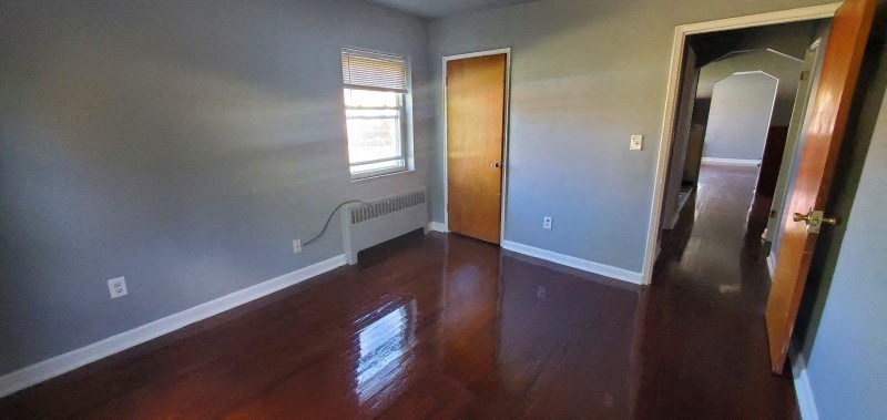 a empty living room with wooden floors and a door