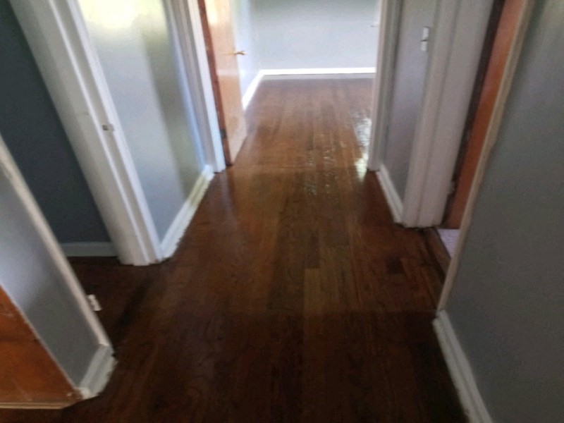 a hallway with hard wood floors and white walls