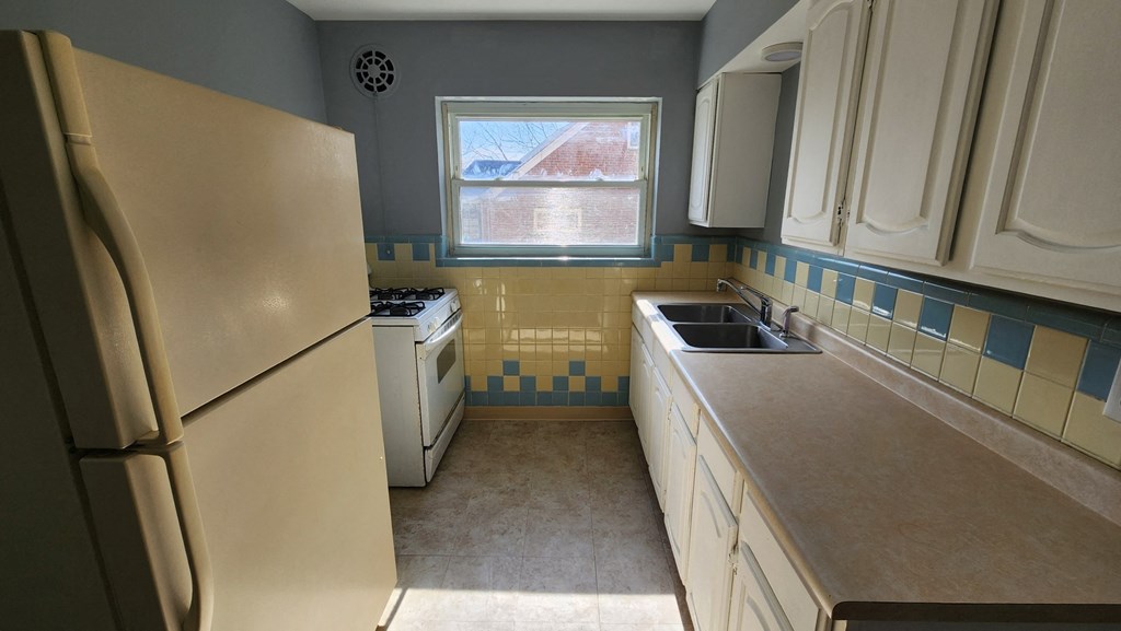 a kitchen with a sink and a refrigerator
