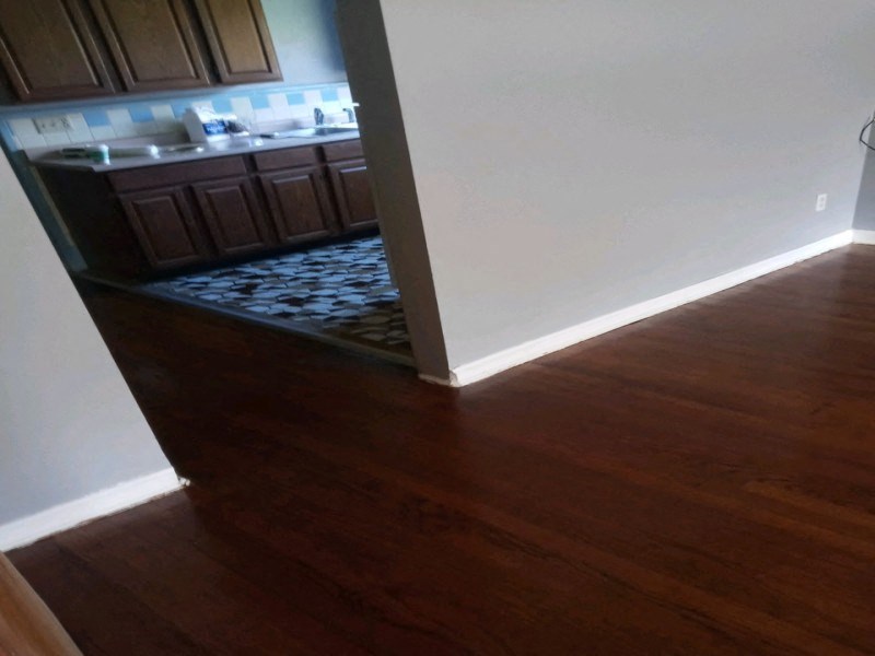 an open doorway into a kitchen with wood flooring