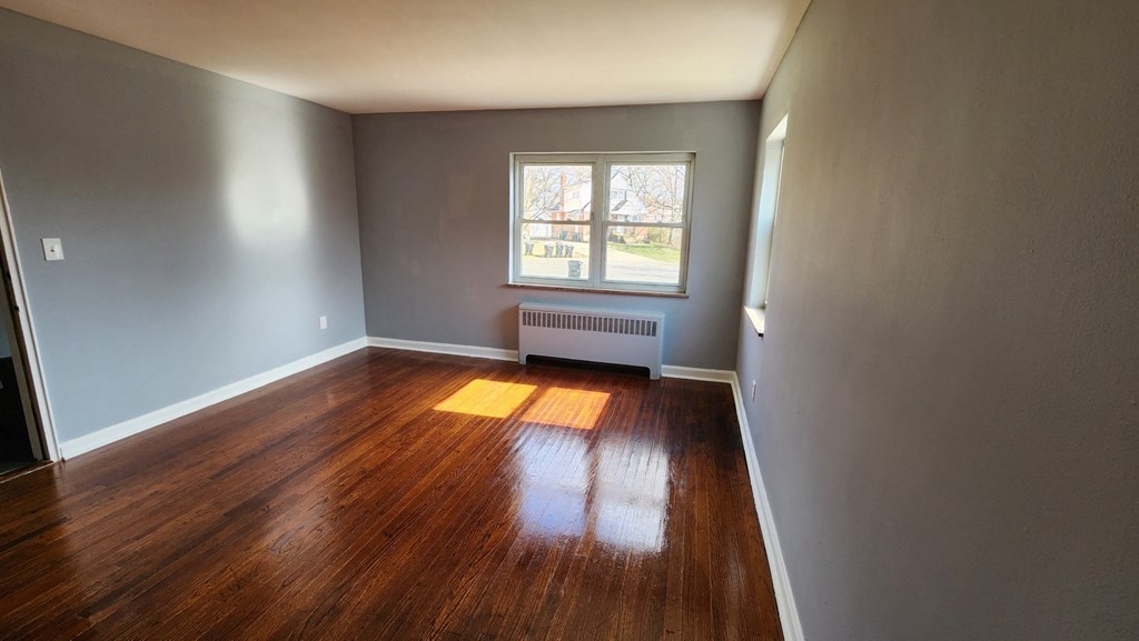 the living room of a house with wooden floors and a window