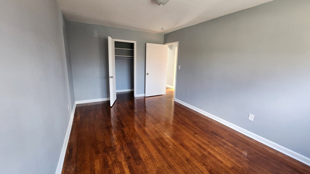 a living room with wood floors and grey walls and a closet