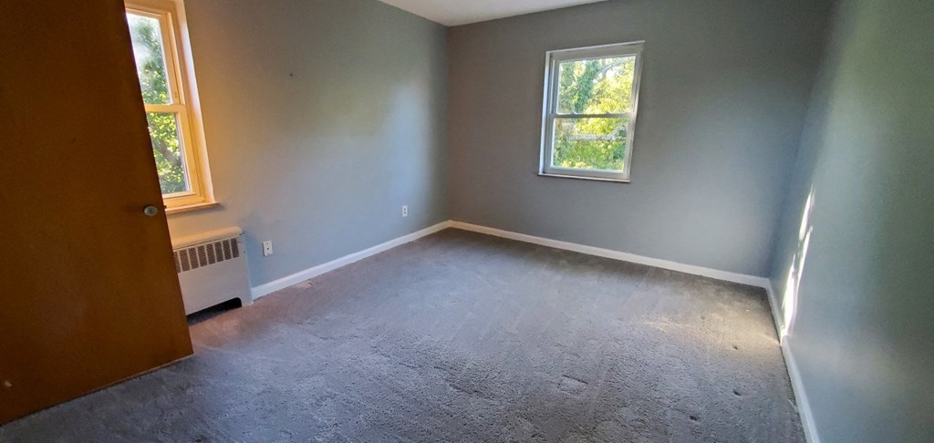 an empty room with gray walls and a window