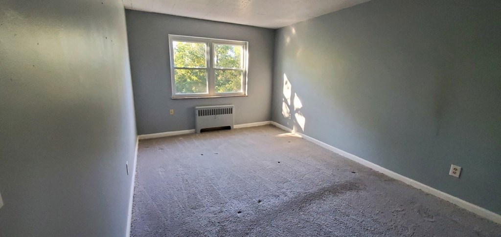 an empty room with gray walls and a window