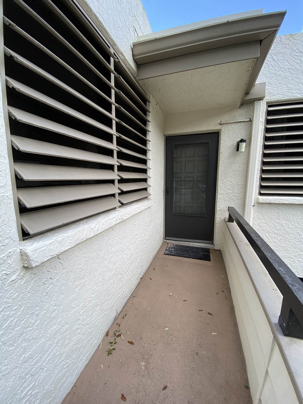 a walkway leading to a house with a black door