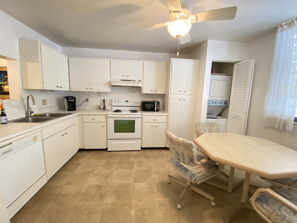a kitchen with white cabinets and a table and chairs