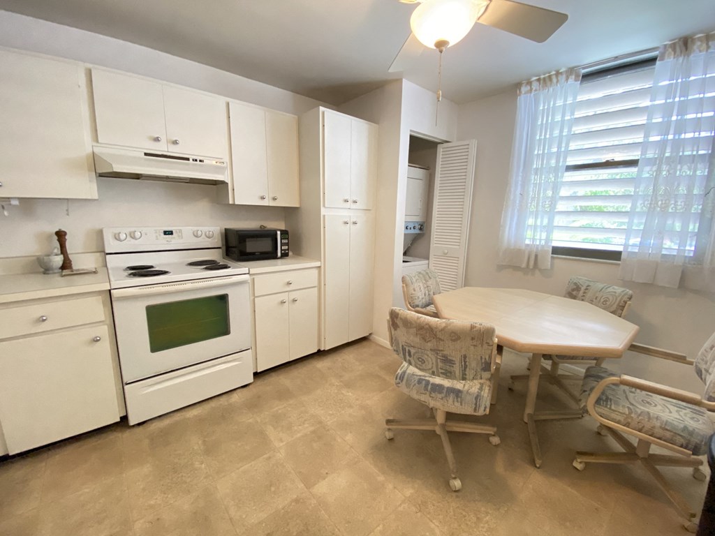 a kitchen with white appliances and a table and chairs