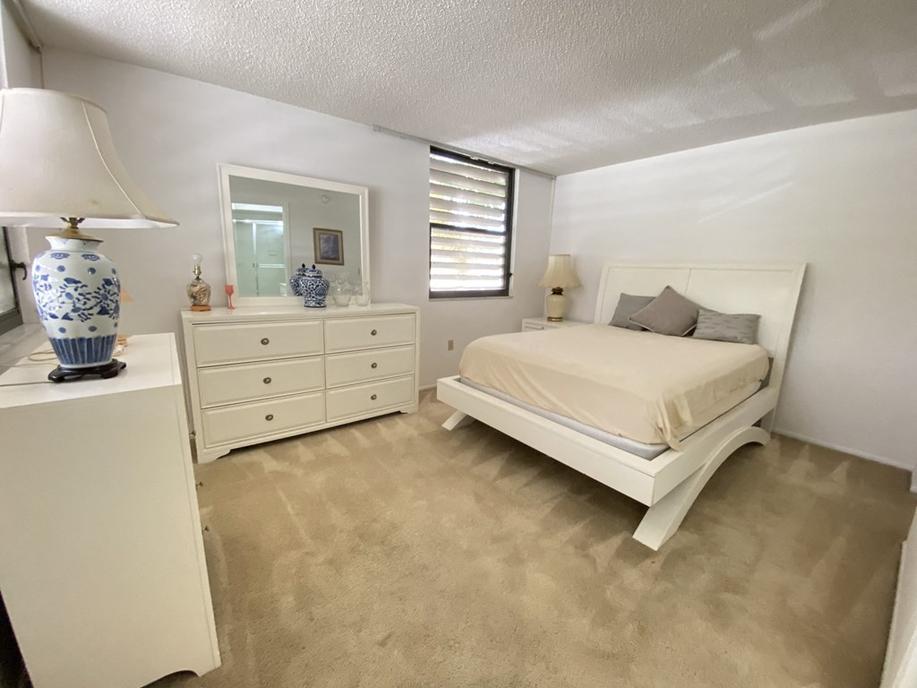 a bedroom with a bed and a dresser and a mirror
