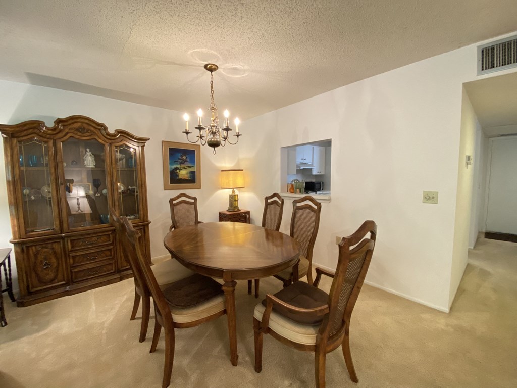 a dining room with a wooden table and chairs and a chandelier
