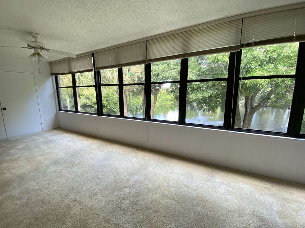 an empty living room with a large window overlooking a river