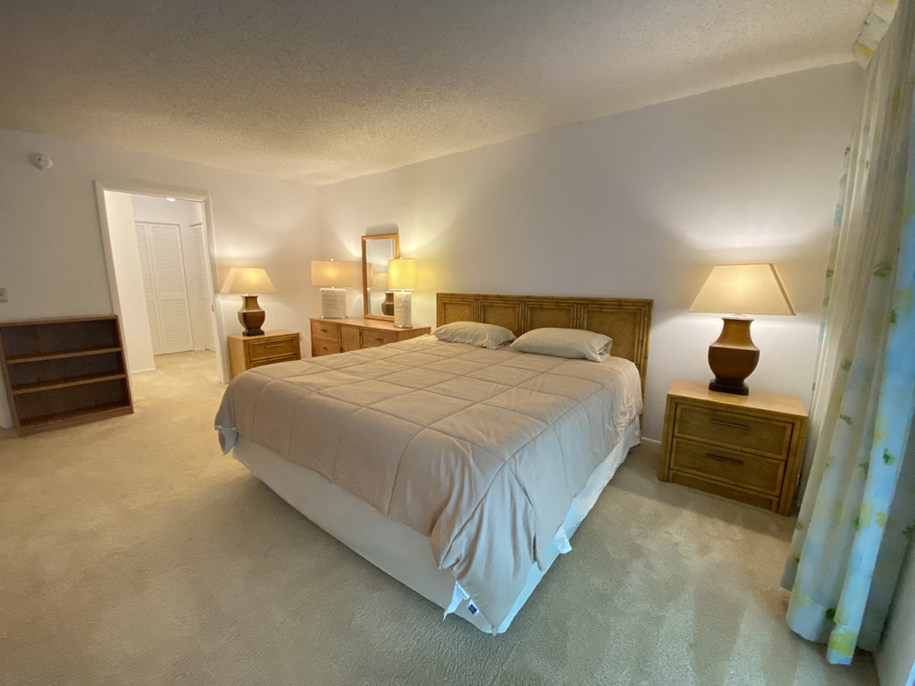 a bedroom with a bed and two lamps and a closet