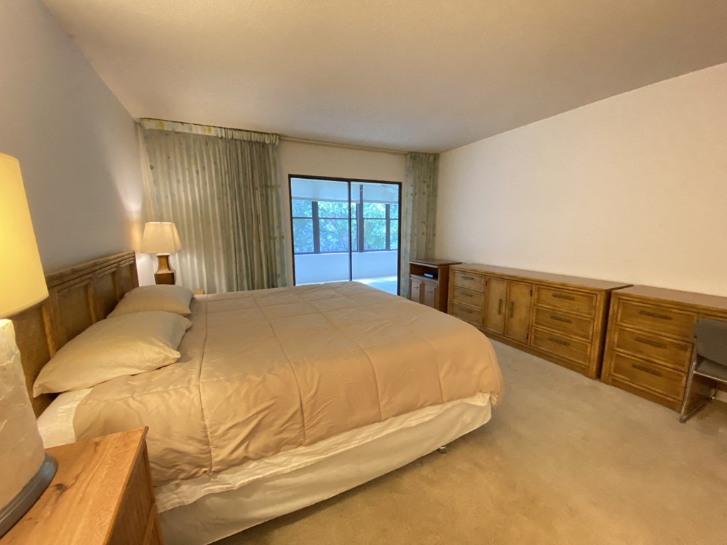 a bedroom with a bed and dressers and a window