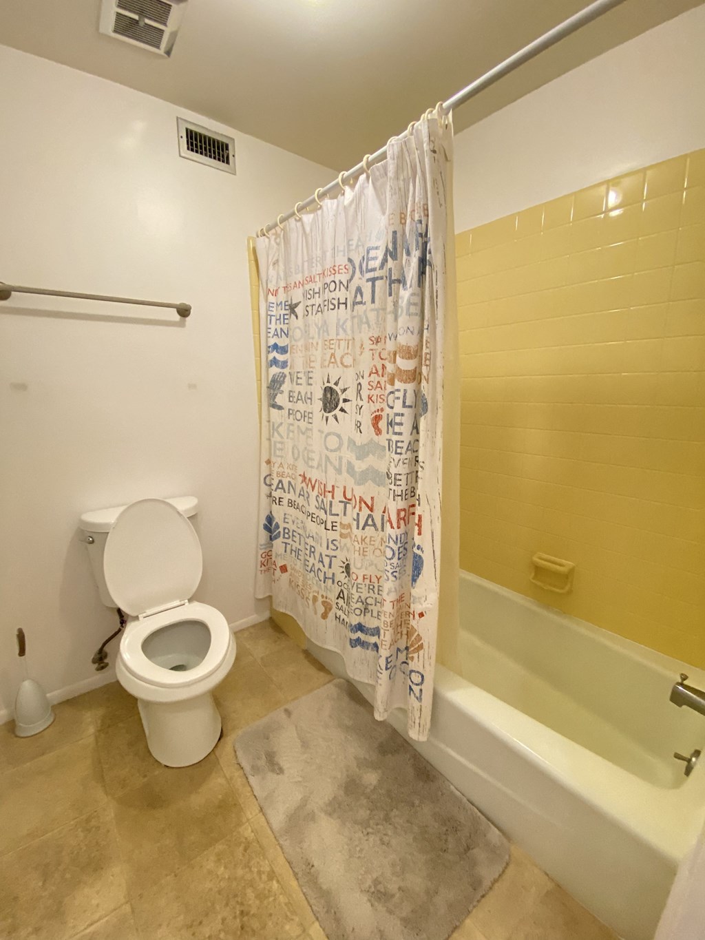 a bathroom with a toilet and a tub and a shower curtain
