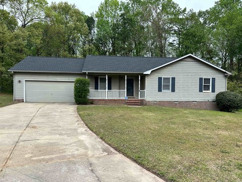 a white house with a porch and a driveway
