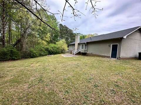 a view of the back of a house with a large yard