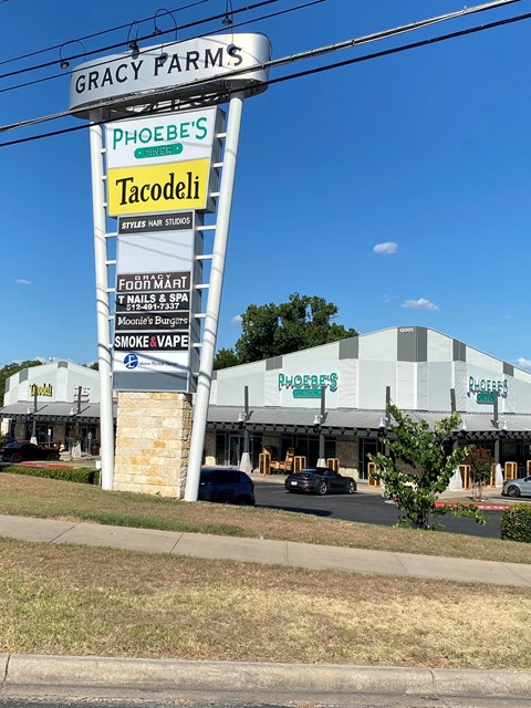 A large sign for Phoebe's and Tacodeli is in front of a building.